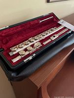 Flute disassembled in case showing body, foot joint, headjoint