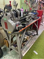 Full view of lathe on stand with accessories underneath