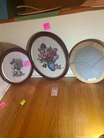 Front view of three framed needlepoint pictures