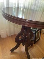Full view of oval wood table, pedestal and legs