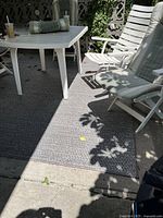 Full view of grey woven outdoor rug under patio table and chairs