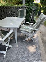 Table and three chairs showing overall style and cushions