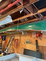 Full side view of green canoe suspended from ceiling