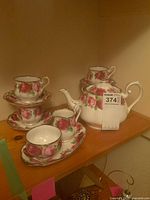 Full tea service showing teapot, cups, saucers, creamer, sugar bowl on tray