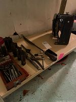 Shelf with tap and die set, die stocks, tap wrench, pry bar, circular saw housing