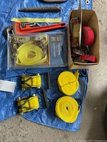Overall lot showing Ridgid wrench, packaged strap set, rolled straps, ratchet mechanisms, box of additional straps