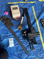 Overview of Quick Vise, pipe wrench, battery charger, nail puller on tarp