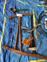 All items laid out: mallet, sledge hammer, bow saw, cast iron ladle and bracket