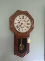 Front view of Ansonia regulator wall clock showing dial and pendulum