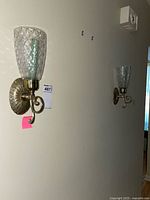 Both brass and glass sconces mounted on wall