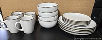 Full 16-piece set showing plates, bowls, mugs