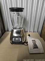 Blender assembled with jar, lid and manual on side