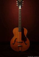 Front view of 1956 Harmony Patrician guitar showing spruce top, f-holes, pickguard, bridge and tailpiece