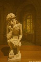 Front view of carved seated Christ figure on wood base