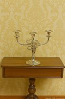 Front view of silver-plated five-arm candelabra on table