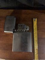 Lighter open beside measuring tape showing height about 7 inches