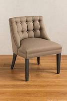 Full view of accent chair showing upholstery, tufted back, seat, and legs