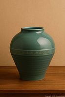 Front view of celadon vase showing shape, glaze, and Greek key band