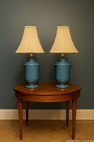 Both matching blue ceramic lamps with shades on table