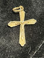 Front view of yellow gold crucifix pendant with bail visible