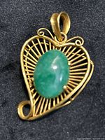 front view of gold heart pendant with jade center