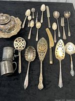 Group shot showing all silver-plated pieces laid out on black background