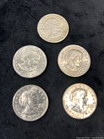 Group of five Susan B. Anthony dollar coins on black background