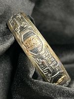 Close-up of bracelet exterior showing silver body and gold embellishment