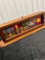 Front view of wooden display case showing medals and patches