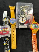 Four watches grouped: Simpsons, Aladdin, Lorus Donald Duck in case, Hulk