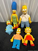 Group shot of five Simpsons plush dolls