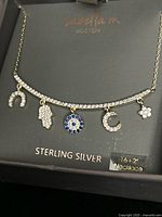 Necklace in branded box showing full view and five charms