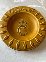 Top view showing Carlsberg Biere Beer text, crown C emblem, leaf motif