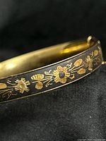 Close-up of gold tone floral damascene inlay on bracelet exterior