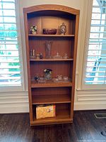 Front view of full-height bookcase showing shelves and arched top