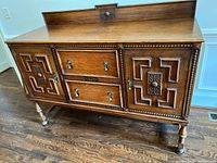 Front view of sideboard showing doors, drawers, gallery, legs