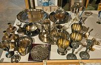 Overview of silverplate items on table including trays, goblets, candlesticks, bowls, coasters, pitchers