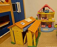 Two of the Dora dollhouses shown closed and open with accessories nearby