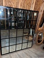 Full view of rectangular multi-pane mirror leaning against unfinished wall