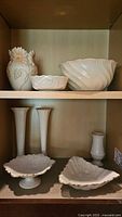 Upper shelf showing daisy relief vase, swirl bowl, small bowl