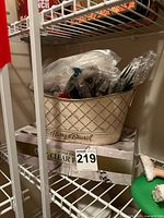 Box of Berkeley Jensen forks and bucket of assorted utensils on shelf