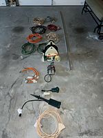 All items spread out on floor showing cords, reel, adapters and stake.