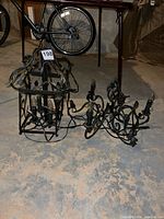 Both wrought iron chandeliers on floor showing overall forms