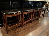 Four bar stools lined under counter showing overall style and quantity