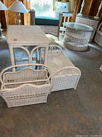 Front view showing white wicker side table, magazine rack, lap table