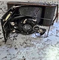 Front open view of the antique Voigtländer IBSOR D.R.P. folding camera showing the lens, shutter mechanism, and wire viewfinder.