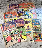 Photo showing a collection of 11 vintage Archie comic books including titles like Archie, Betty and Veronica, Little Archie, Jughead, and Archie's Pals 'n' Gals.