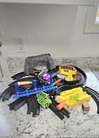 Overall view of the assorted BATMAN GeoTrax train set pieces arranged on a countertop showing tracks, vehicles, and interactive accessories.