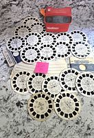 View-Master viewer and all included reels laid out on surface, showing quantity and condition