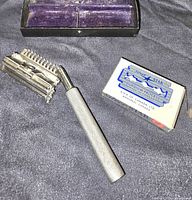 Open black case with safety razor handle, razor head, box of Silver Star blades, and three additional blade covers.